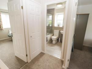 a bathroom with a toilet and a bath tub at 7 Cwrt Y Cadno in Llantwit Major +31 photos