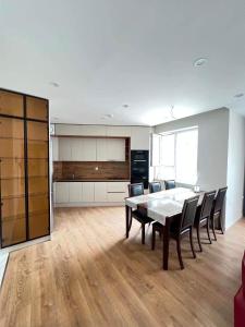 a kitchen and dining room with a table and chairs at Mandala Garden Luxury Apartment in Ulaanbaatar