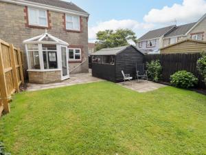 a backyard of a house with a black shed at 7 Cwrt Y Cadno in Llantwit Major