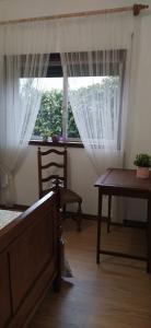 a bedroom with a bed and a table and a window at Casa da Corredoura in Penafiel