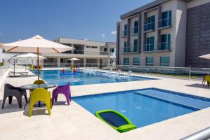 a pool with chairs and a table and an umbrella at Hotel Las Olas Palermo in Neiva