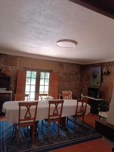 a dining room with a white table and chairs at Casa da Corredoura in Penafiel