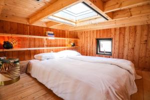 a bedroom with a large bed in a wooden room at Tiny House of Happiness - shared hot tub in Otterlo