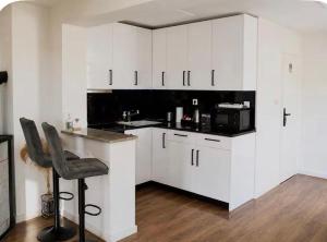a kitchen with white cabinets and a chair in it at Holiday home Damian in Zagreb