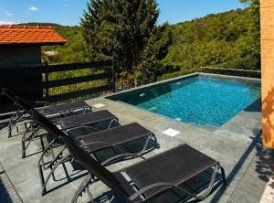 a group of chairs sitting next to a swimming pool at Holiday home Damian in Zagreb