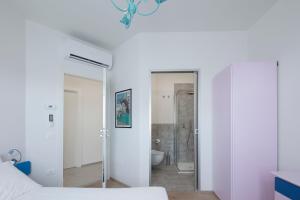 a bedroom with a bed and a bathroom with a mirror at VItruVIo POP in Fano +27 photos