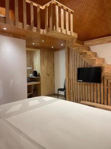 a bedroom with a bed and a tv on a wall at Wanderlust Beach Villa in Agatti