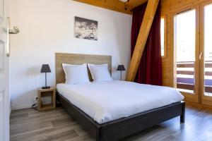 a bedroom with a large bed and a window at Résidence Odalys Le Pelvoux in La Plagne