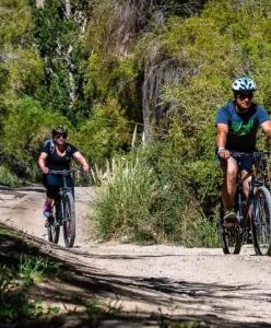 two people riding bikes down a dirt road at Alcohuaz Indomito in Alcoguaz