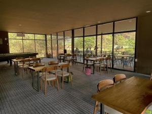 a dining room with tables and chairs and windows at Openview Resort Thakhek in Thakhek