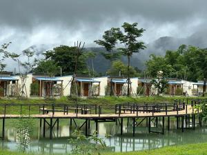a group of houses with a dock in the water at Openview Resort Thakhek in Thakhek