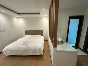 a bedroom with a white bed and a large window at Openview Resort Thakhek in Thakhek