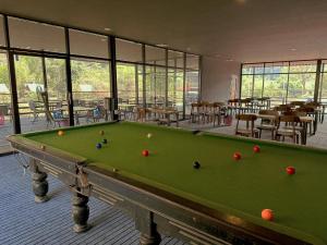 a pool table in a room with tables and chairs at Openview Resort Thakhek in Thakhek