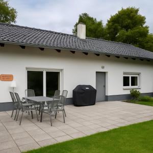 a patio with a table and chairs in front of a house at Natur pur Katharina in Kraiburg am Inn