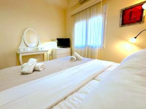 a bedroom with a bed with two towels on it at Central Mytilene City-View Apartment for 7 in Mytilene