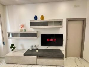 a living room with a tv on a wall at Silviaapartment in Battipaglia +12 photos