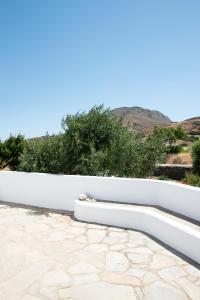 a white retaining wall on a patio at Visinokipos House in Mirsíni