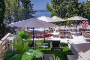 an outdoor patio with tables and chairs and umbrellas at Boutique Hotel Solterra - Crikvenica in Crikvenica