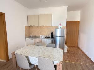 a kitchen with a table and chairs and a refrigerator at Apartments Palma Novalja in Novalja