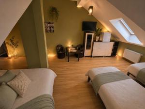 a attic bedroom with two beds and a tv at Dworek w Karpaczu in Karpacz