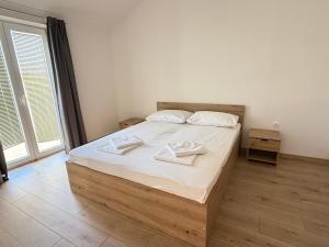 a bedroom with a bed with two towels on it at Apartments Palma Novalja in Novalja