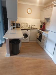 a kitchen with a sink and a washing machine at Coastal Apartment in Malahide