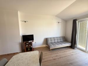 a living room with a couch and a television at Apartments Palma Novalja in Novalja