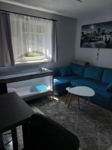 a living room with a blue couch and a table at Agroturystyka Yvonne in Zawoja