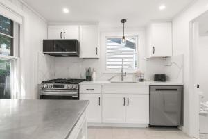 a white kitchen with a sink and a stove at Steps to the Beach Cozy Central AC in Yarmouth +35 photos