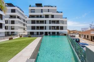 an apartment with a swimming pool in front of a building at Casa Maku in San Pedro del Pinatar