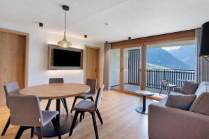 a living room with a table and chairs and a balcony at Residence Froy in Resia