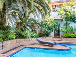 a chair sitting next to a swimming pool at Constantia Hotel and Conference Centre in Midrand +23 photos