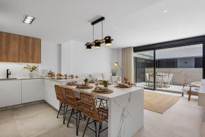 a kitchen with a large white island with chairs at Casa Maku in San Pedro del Pinatar