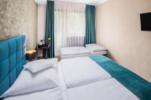 ein Hotelzimmer mit zwei Betten und einem Fenster in der Unterkunft Hotel Park in Piešťany