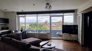 a living room with a couch and a large window at Modern skyline-view condo at a luxury complex in Vilnius