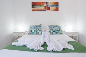 a bed with white sheets and a bow on it at Rayito de sol 3 in Costa de Antigua +20 photos