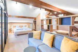 a living room with a blue couch and a bed at Münsterhus Josefs Alpine Lodge in Schruns