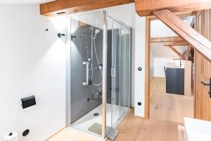 a glass shower in a bathroom with wooden ceilings at Münsterhus Josefs Alpine Lodge in Schruns +93 photos