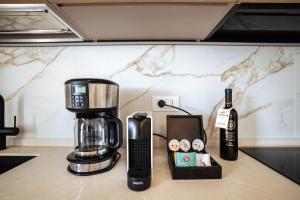 a coffee maker and a bottle of wine on a counter at Corte Fossalta - Casa Linda in Lazise