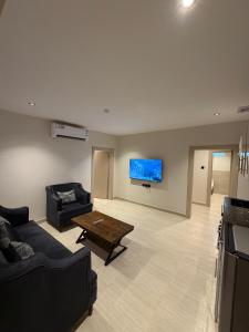 a living room with a couch and a table at شقق درة القويعية in Al Quway‘īyah