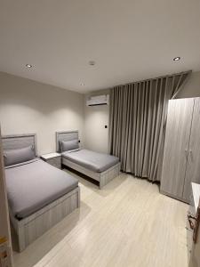 a bedroom with two beds and a window at شقق درة القويعية in Al Quway‘īyah