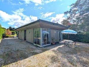 a small shed with a table and an umbrella at Down Ende House Accommodation in Looe