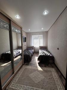 a bedroom with two beds and a cat laying on the floor at Квартира in Temirtaū