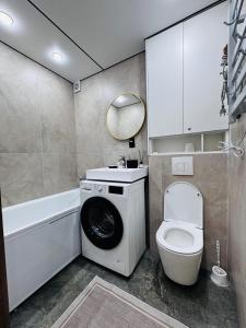 a bathroom with a washing machine and a toilet at Квартира in Temirtaū