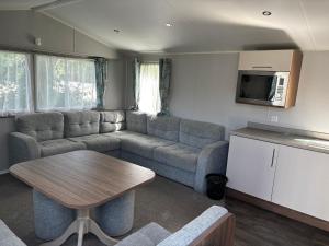 a living room with a couch and a table at Explorer45 in Lytchett Minster