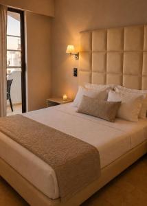 a large bed with a large headboard in a bedroom at RHODEA Mar in Faliraki