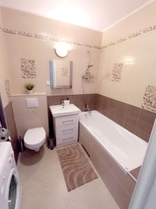 a bathroom with a tub and a toilet and a sink at Royal Nest Apartment Sandomierz in Sandomierz +10 photos