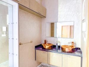 a bathroom with two copper sinks on a counter at Petit-villa avec piscine in Marrakesh +14 photos