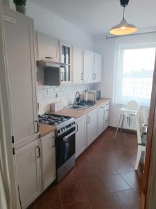 a kitchen with white cabinets and a stove top oven at Royal Nest Apartment Sandomierz in Sandomierz