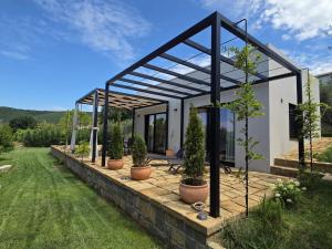 a house with a pergola and potted plants at House B in Dekani